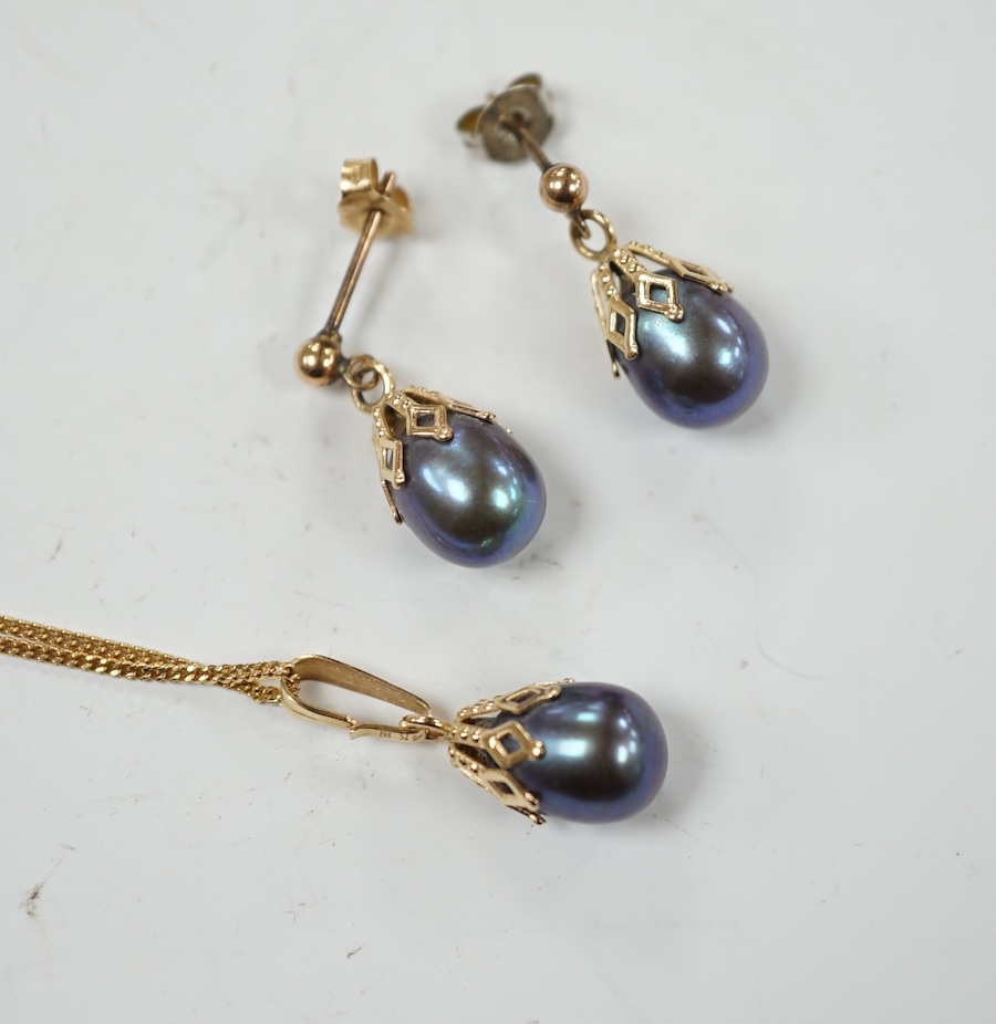 A 14k and Tahitian cultured pearl set pendant, 22mm, on an Italian Uno-A-Erre 9ct gold chain, 46cm, together with a pair of similar pair of yellow metal and Tahitian cultured pearl set ear studs, gross weight 5.1 grams.